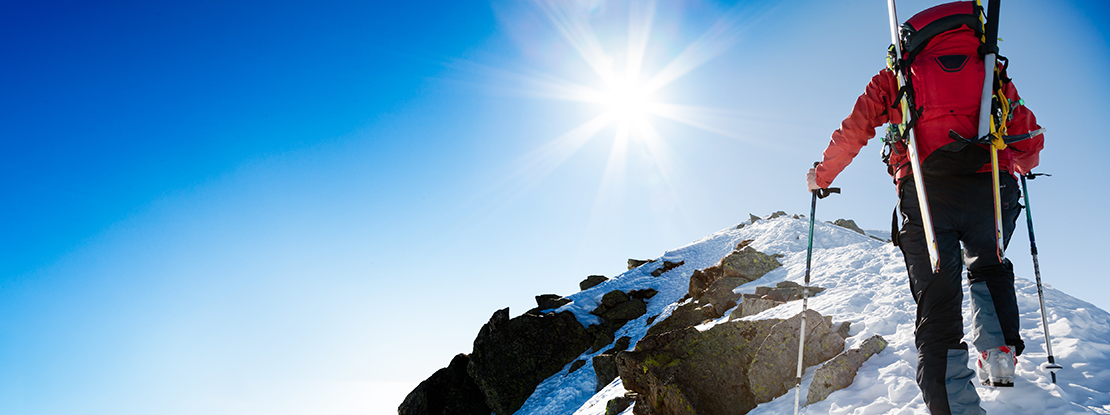 Man Climbing a mountain on a warm, sunny day